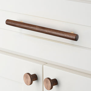 In-use view of slim walnut wood bar cabinet pull with gold-colored mounts, style #4 (160 mm).