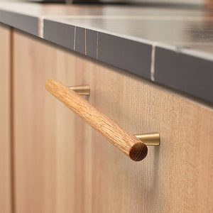 In-use view of slim white oak bar cabinet pull with gold-colored mounts, style #4 (160 mm).