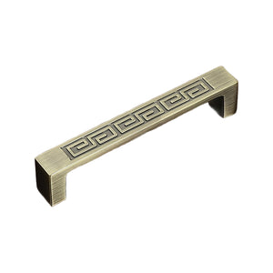 Straight bar pull with a raised Greek-key pattern along the face, variant #26, 96 mm.