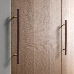 Walnut wood bar cabinet pulls with brass mounts installed on wood cabinet doors.