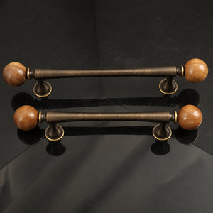 Two bronze-finish bar cabinet pulls with dark wood ball ends, shown from the side.