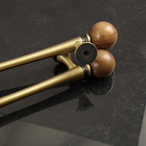 Two brass bar cabinet pulls with dark wood ball ends, showing rear mounting points.