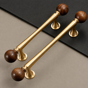 Two brass bar cabinet pulls with dark wood ball ends, shown from the side.