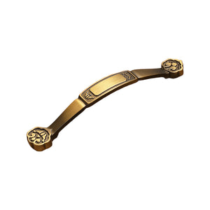 Bronze-tone arched bridge pull with a gold-tone center plaque and ornate ends, option No. 10, 128 mm.