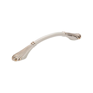 Ivory-colored curved bridge pull with fluted end plates and gold-tone accents, 128 mm.