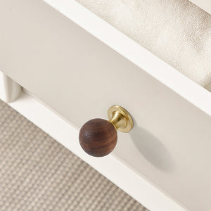 In-use view of dark wood ball cabinet knob on a brass pedestal, style #1 (25 mm).
