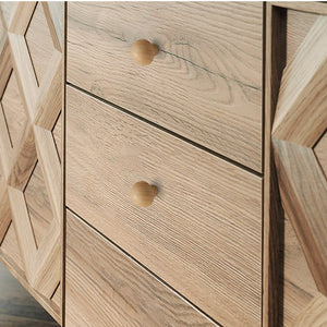 Round beech wood cabinet knobs installed on a natural wood chest of drawers.