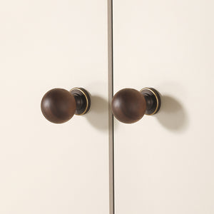 In-use view of dark wood ball cabinet knob with antique bronze brass base, style #10 (30 mm).