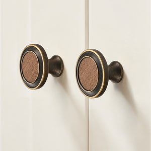 In-use view of flared antique bronze brass cabinet knob with round dark wood inset, style #13.