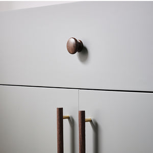 In-use view of turned walnut wood cabinet knob with a stepped round base, style #2.