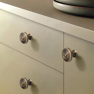 In-use view of concentric-ring antique bronze brass cabinet knob, style #23.