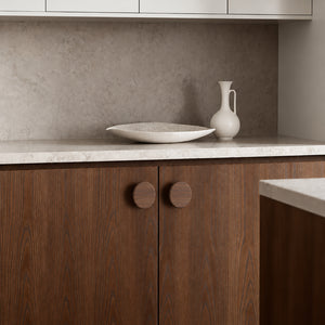 In-use view of flat round walnut wood cabinet knob, style #3 (48 mm).