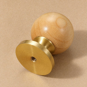 Side and mounting view of light wood ball cabinet knob on a brass pedestal, style #3.