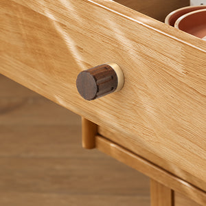 In-use view of walnut wood cylindrical cabinet knob with brass base, style #4 (45 mm).