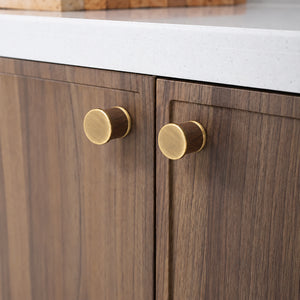 In-use view of dark wood barrel cabinet knob with brass end caps, style #7 Brass.
