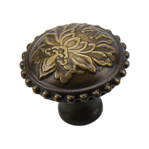 Aged bronze-tone round cabinet knob with raised floral detail and a beaded rim, 32 mm.