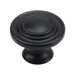 Black round cabinet knob with a smooth center and concentric stepped rings, option No. 1.