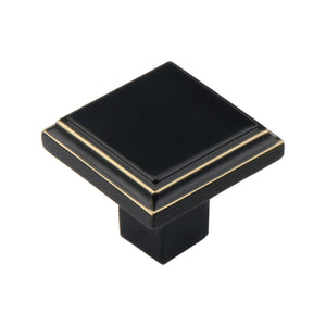 Black square cabinet knob with gold-tone trim, 33 mm.