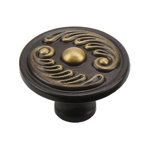 Coffee bronze round cabinet knob with raised gold-tone scrollwork.