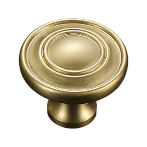 Gold-tone cabinet knob with concentric rings and a smooth domed center, option #3.