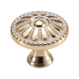 Gold-tone round cabinet knob with raised radial petals and a domed center, option #1.