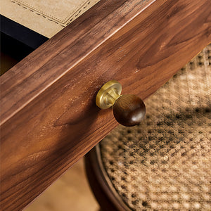 Brass cabinet knob with dark wood ball inset installed on a walnut cabinet drawer.