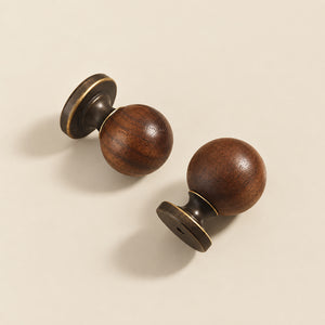 Two dark wood ball cabinet knobs with antique bronze bases, showing side and mounting details.
