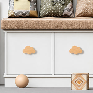 Cloud-shaped wood knobs fitted to white cabinet doors.