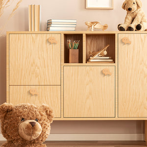 Lion-shaped wood knobs on a light-wood storage cabinet.