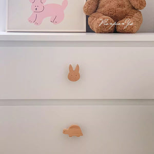 Rabbit-shaped wood knob on a white chest drawer.