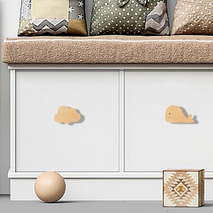 Whale-shaped wood knobs on white cabinet doors.
