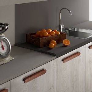 In-use view of slim rounded reddish wood finger pull, 128 mm option.