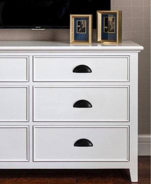 Solid brass open-back cup pulls in Matte Black shown on white cabinet drawers beneath a television.