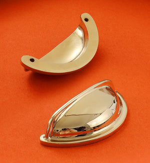 Front and back views of the solid brass open-back cup pull in Polished Gold, showing its reflective face and two mounting holes.