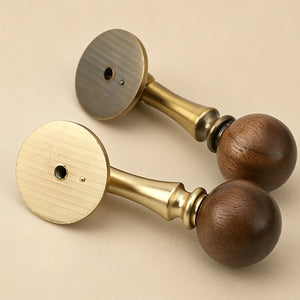 Two brass drop pulls with dark wood ball ends, showing rear mounting holes.