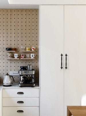 Solid brass rounded dome cup pulls in Antique Bronze on white kitchen drawers beside a coffee station.