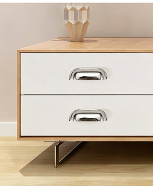 Solid brass soft-corner cup pulls in Polished Chrome on the white drawers of a wood-grain chest.