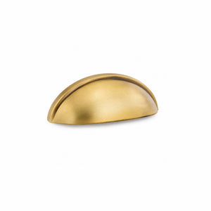 Burnished brass half-moon cup pull angled on white to show its curved face and raised rim.