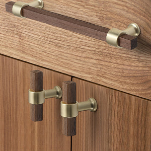 In-use view of faceted walnut wood T-bar cabinet pull with a round brass center mount, style #3.