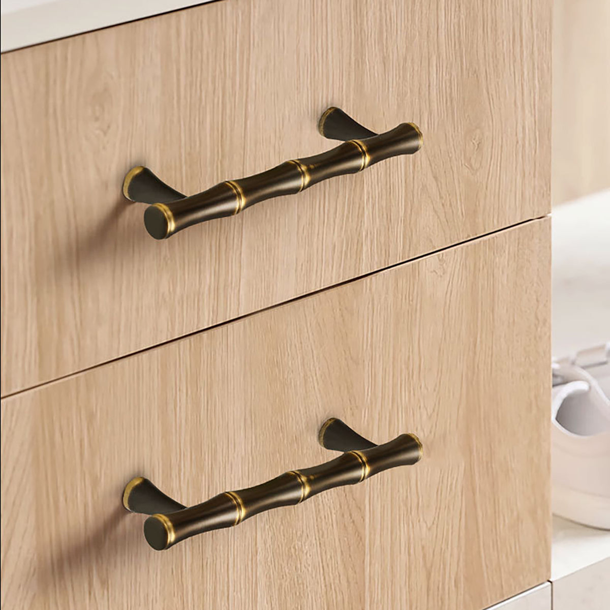 In-use view of segmented dark antique brass bar cabinet pull with gold rings, style #11 (96 mm).