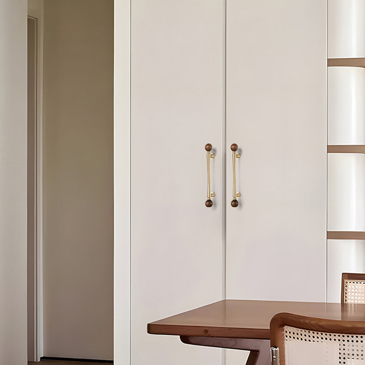 In-use view of brass bar cabinet pull with dark wood ball ends, style #17 (128 mm).