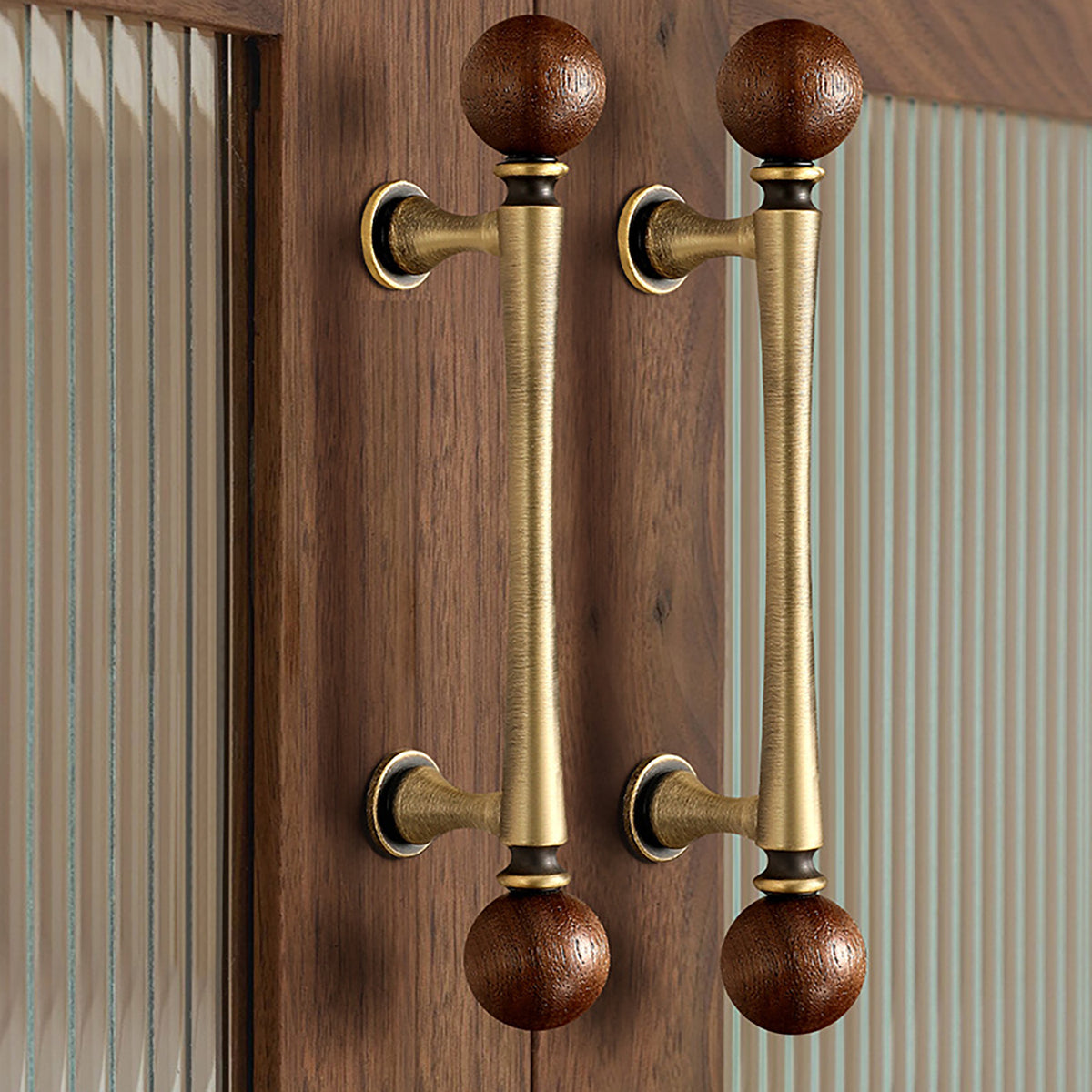 In-use view of brass bar cabinet pull with dark wood ball ends, style #17 (96 mm).