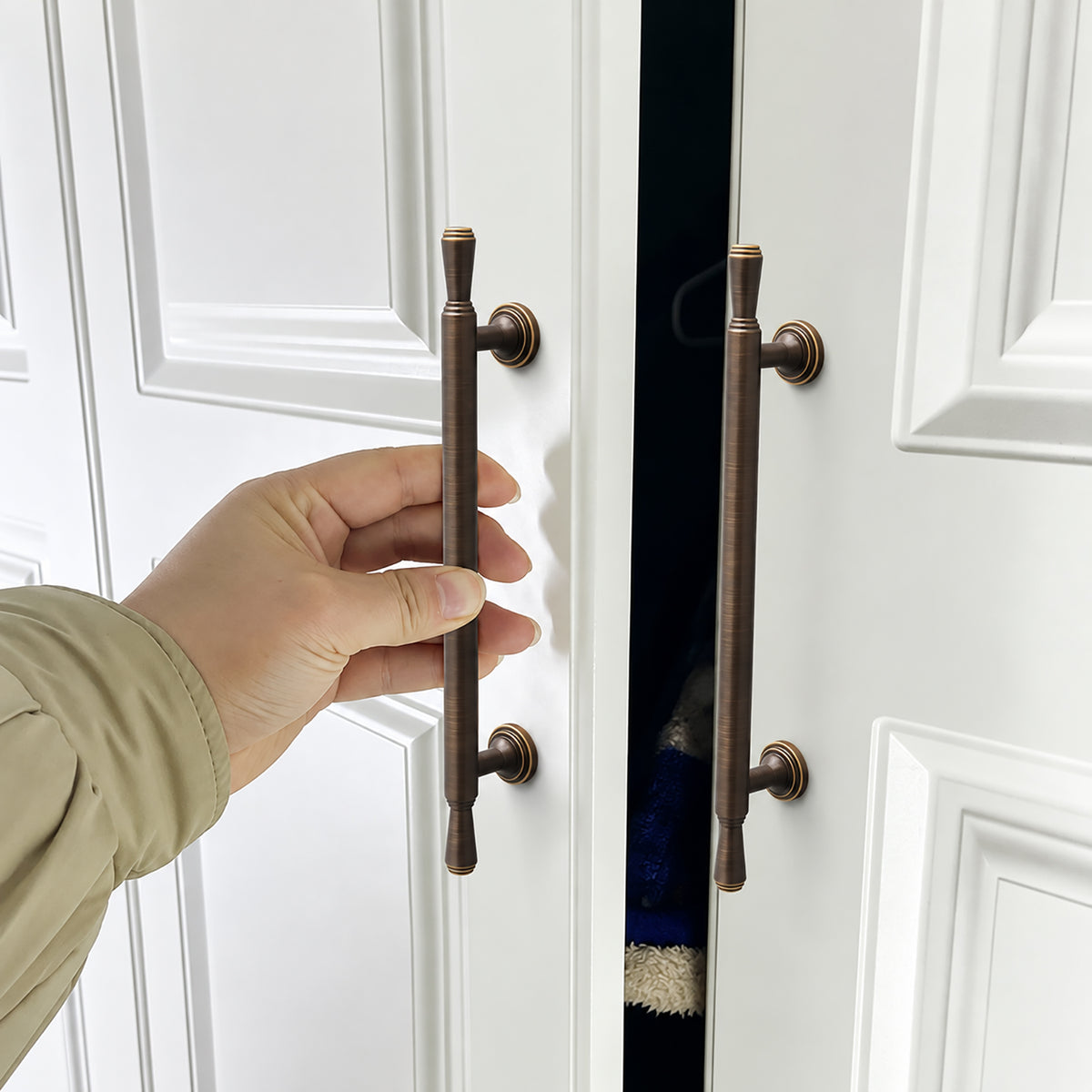 In-use view of dark antique brass bar cabinet pull with flared ends, style #9 (160 mm).
