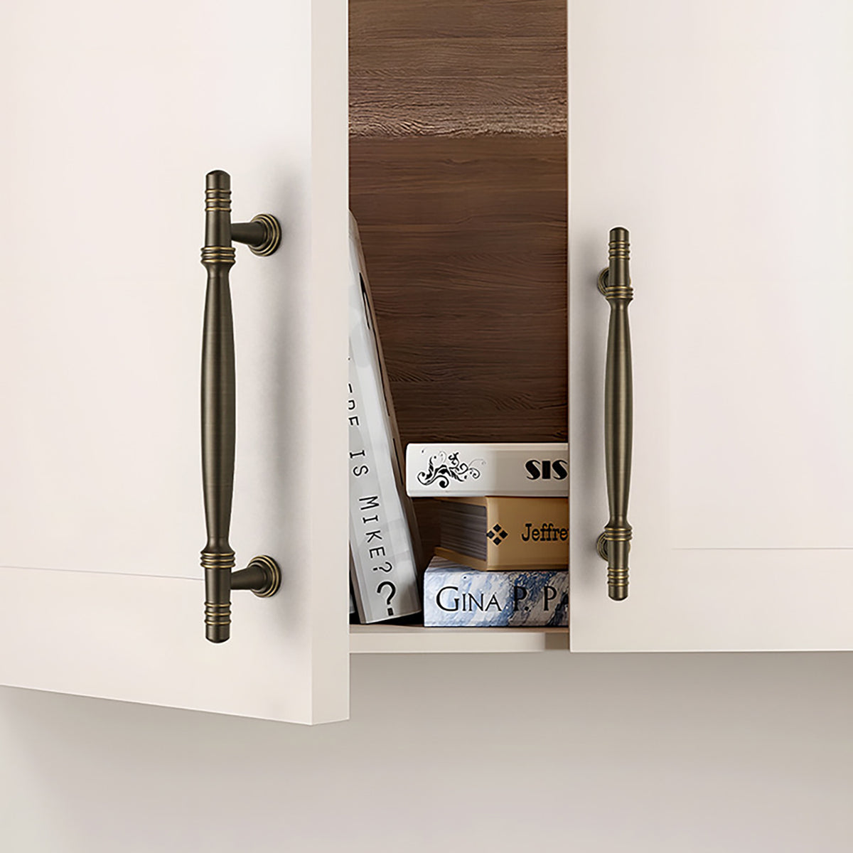 Dark antique brass bar cabinet pulls installed on a white cabinet.