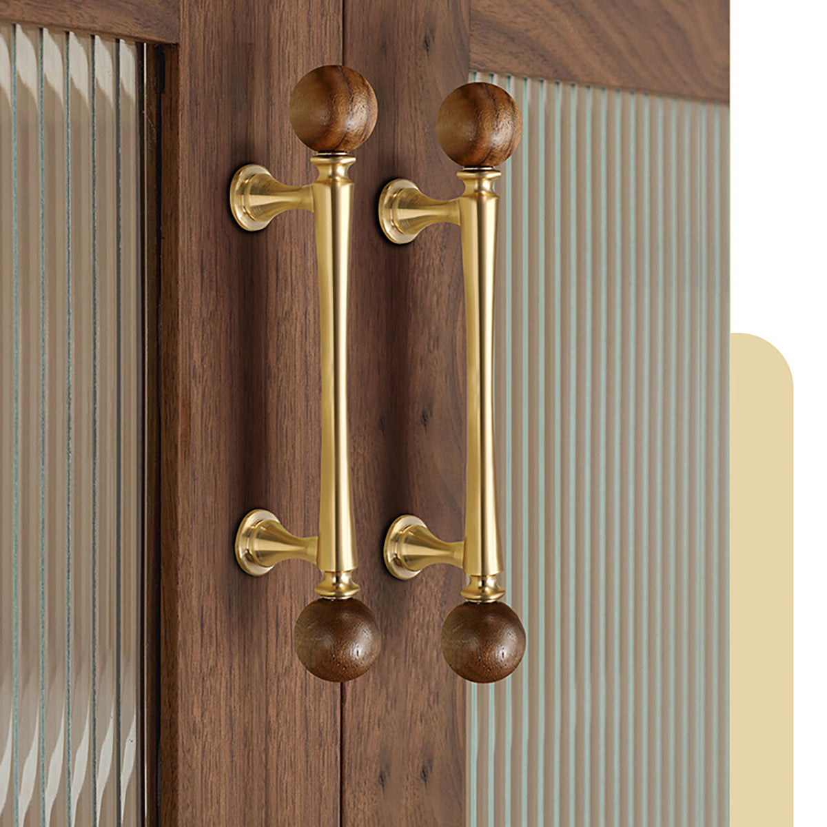 Brass bar cabinet pulls with dark wood ball ends installed on wood cabinet doors.