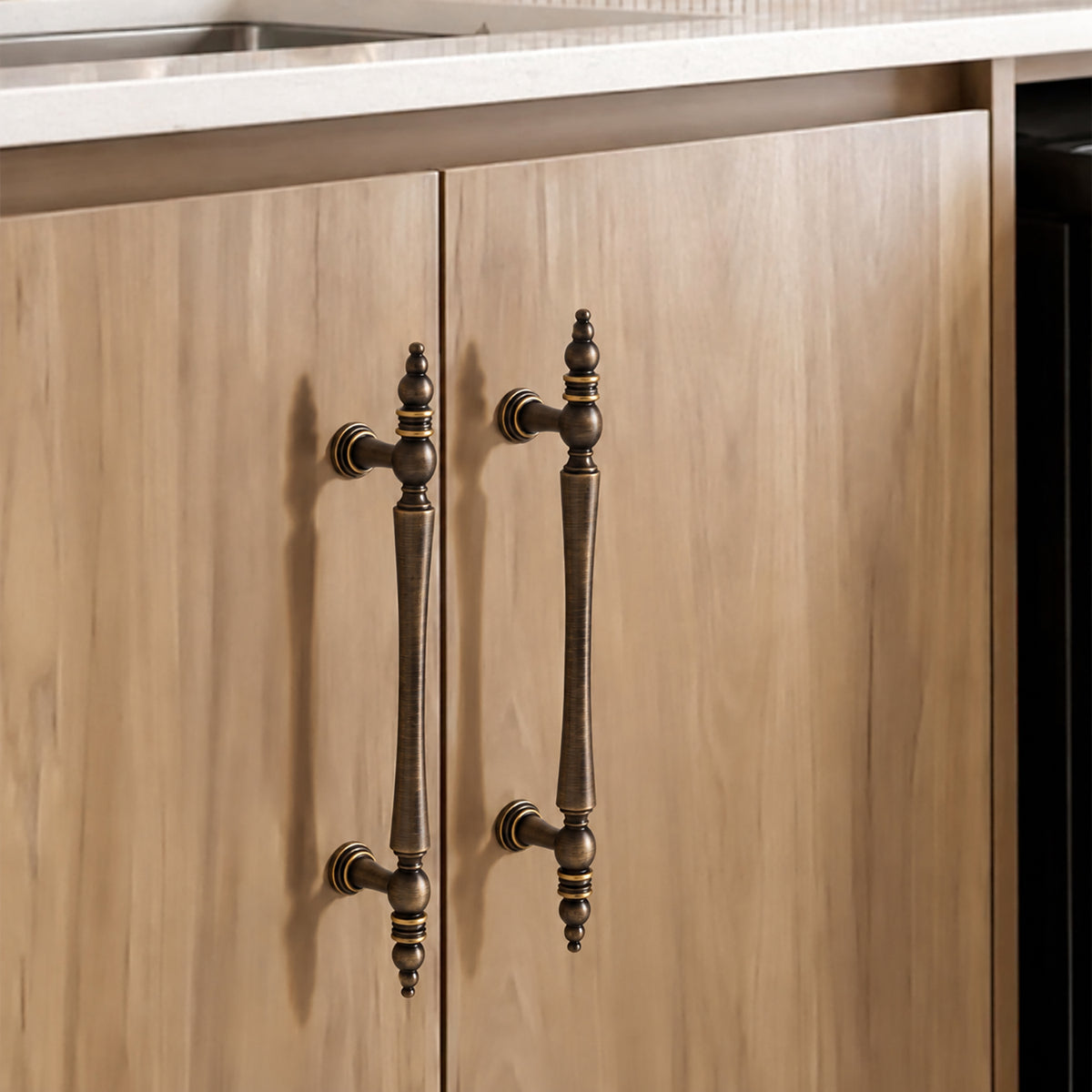 Ornate antique brass cabinet pulls installed on wood wardrobe doors.