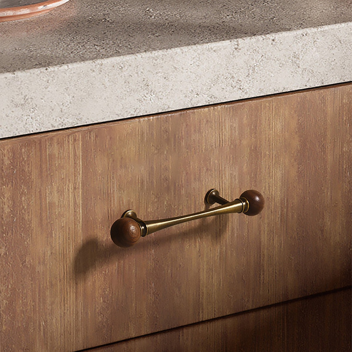 Bronze-finish bar cabinet pull with dark wood ball ends installed on a walnut drawer.