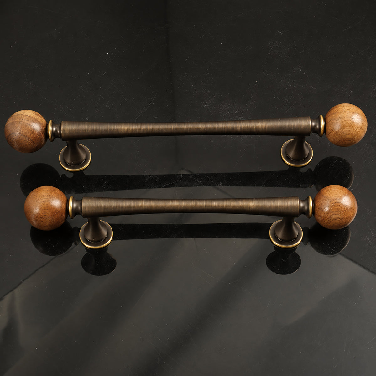 Two bronze-finish bar cabinet pulls with dark wood ball ends, shown from the side.