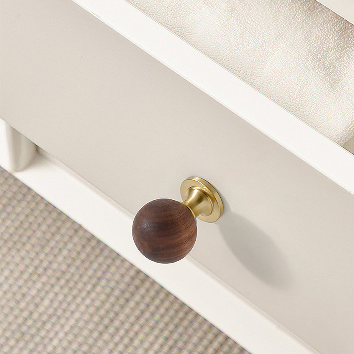 In-use view of dark wood ball cabinet knob on a brass pedestal, style #1 (25 mm).