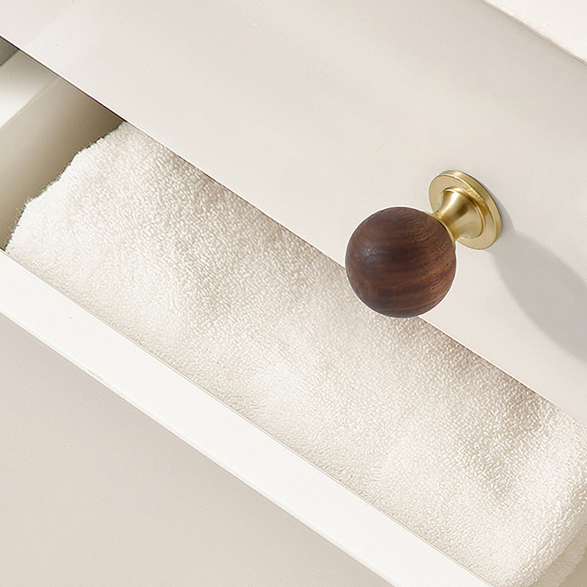 In-use view of dark wood ball cabinet knob on a brass pedestal, style #1 (30 mm).